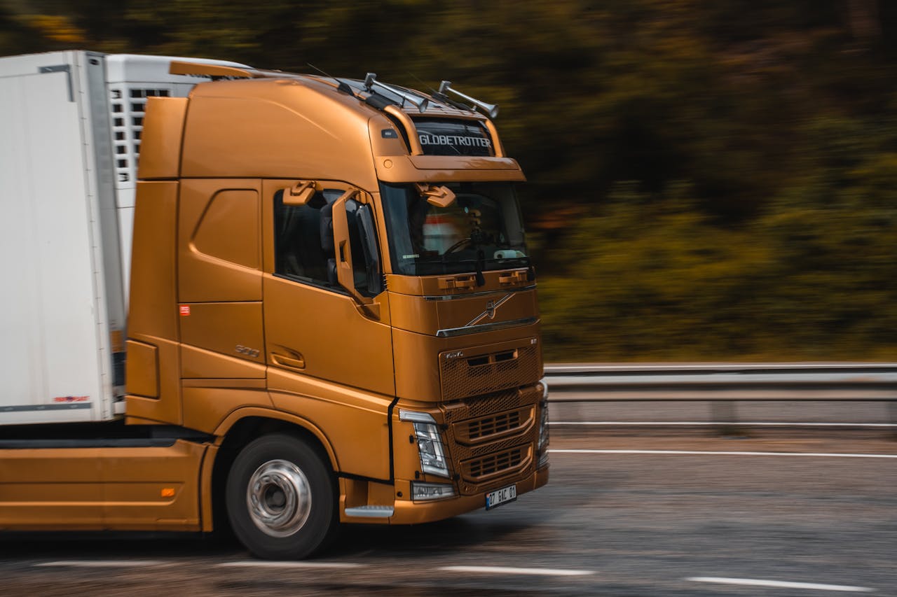 About Orange truck speeding along a highway in Kemer, showcasing transportation and logistics.