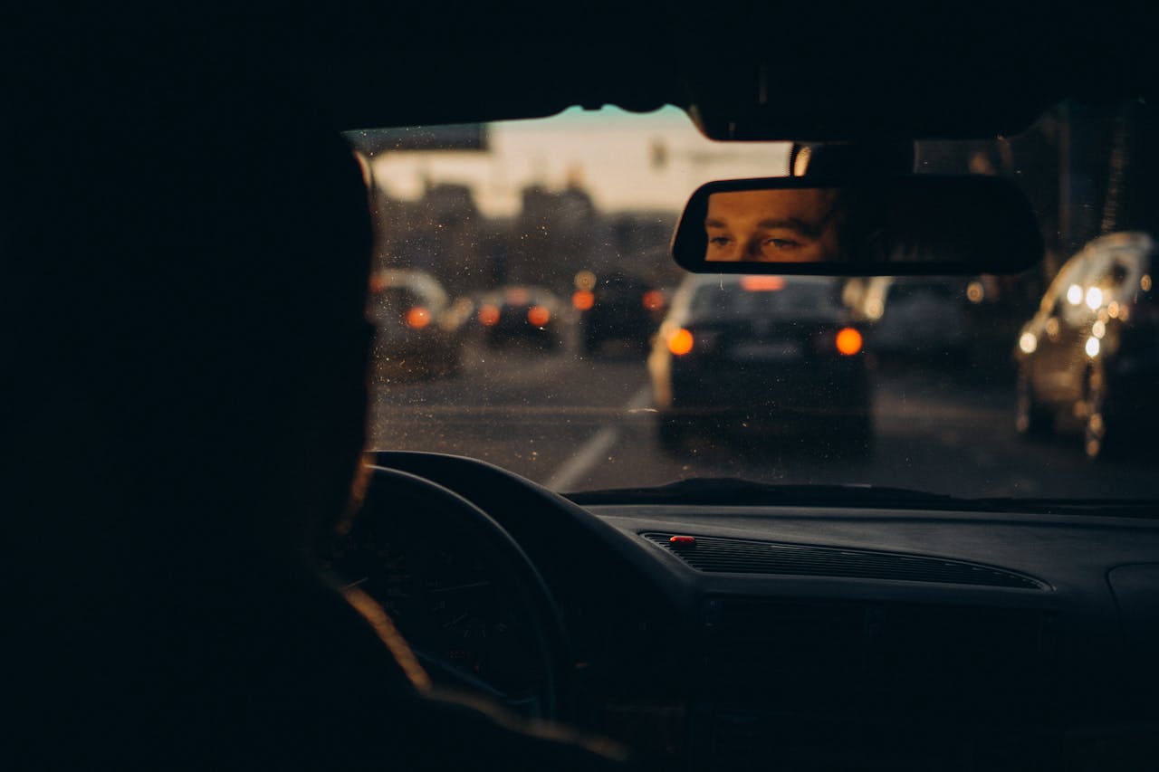 Home Capturing the reflection of a driver amidst evening traffic in Українка, creating a moody urban scene.